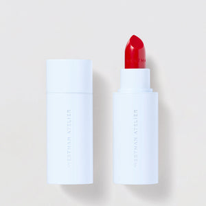 Red lipstick with white casing on a light beige background