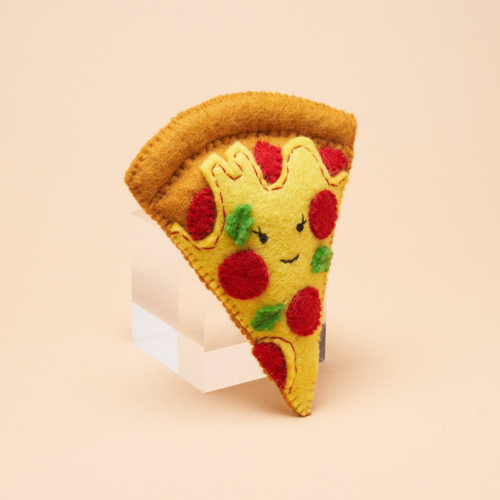 A handmade felt pizza slice dog toy, made by Gone to the Dogs in Brooklyn