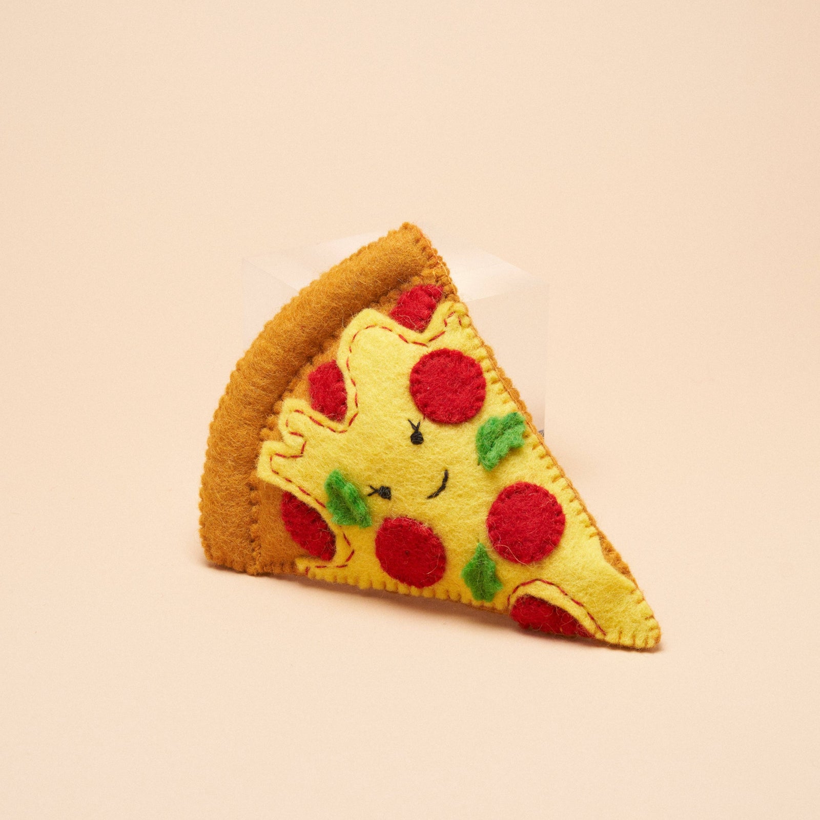 A handmade felt pizza slice dog toy, made by Gone to the Dogs in Brooklyn