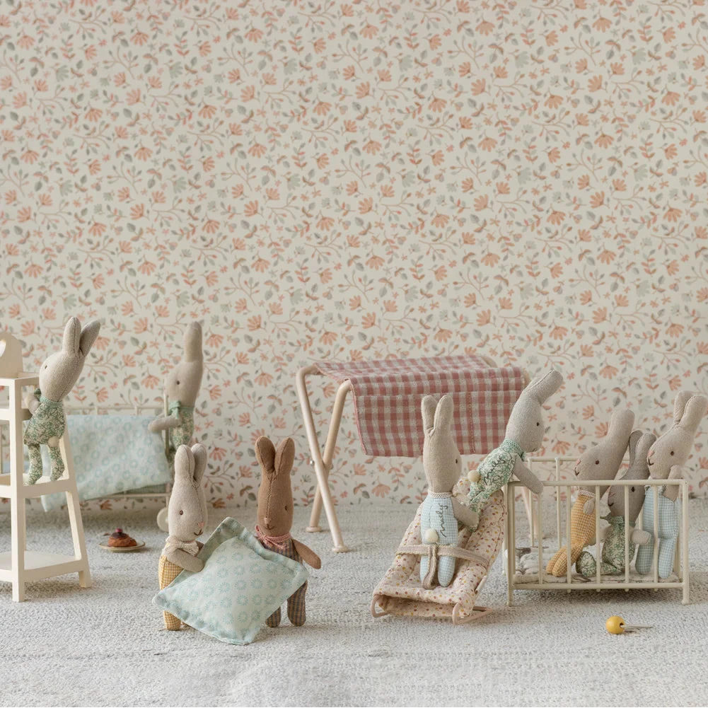 Toy animals on a wooden stand with floral wallpaper background