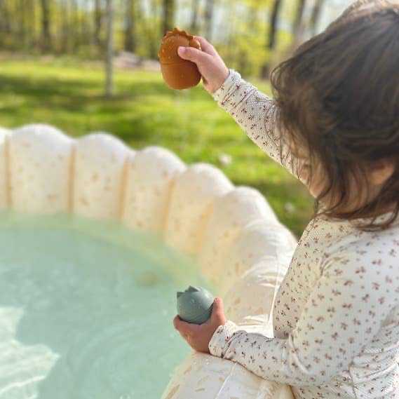 A little girl plays with a cool and Brooklyn neutral water toys