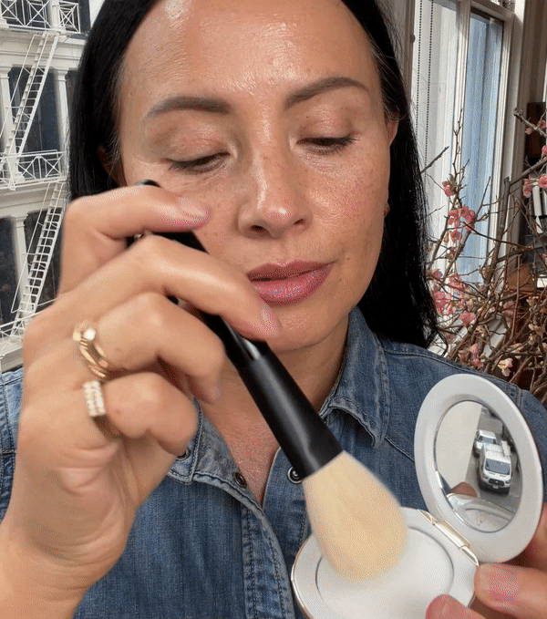 A compact container of Westman Atelier skincare powder with a mirror on the lid, against a white background