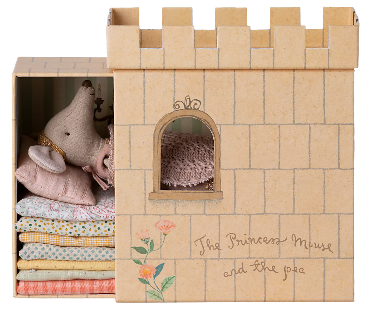 A toy playset featuring a castle with a princess mouse and a pea, inspired by 'The Princess and the Pea' fairytale. The set is primarily beige and includes a bed with mattresses.