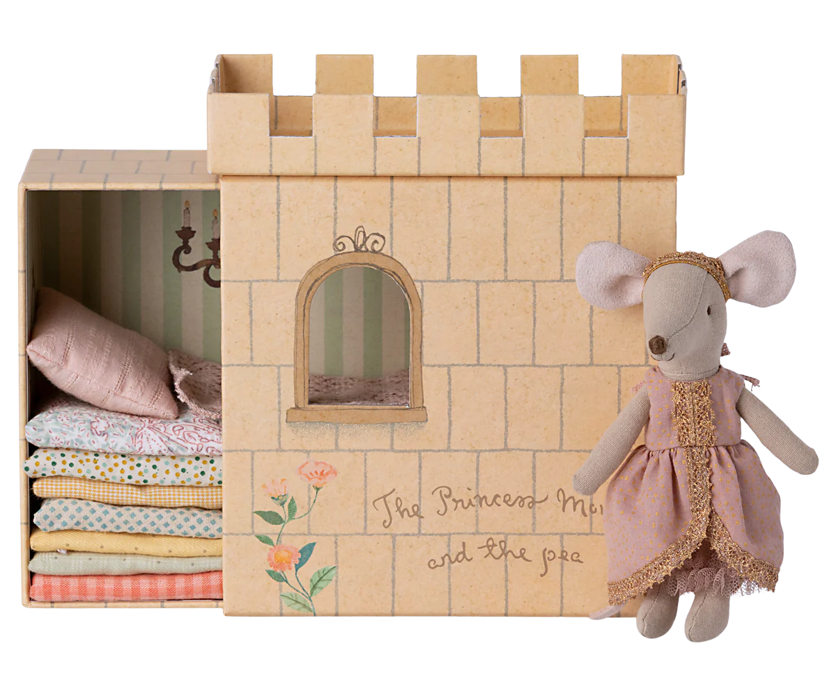 A toy playset featuring a castle with a princess mouse and a pea, inspired by 'The Princess and the Pea' fairytale. The set is primarily beige and includes a bed with mattresses.