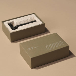 A green box with a black safety razor. 