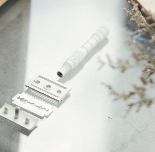 A white safety razor on a white background. 