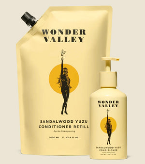 A bottle and refill bag of the Sandalwood Yuzu hair conditioner, made by Wonder Valley in California