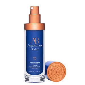 Augustinus Bader skincare product with blue label and bronze cap on a white background