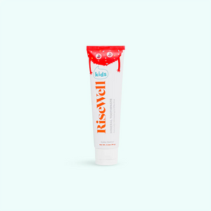 A tube of Risewell Kids Mineral Toothpaste with a red cap and white body, featuring text and branding.