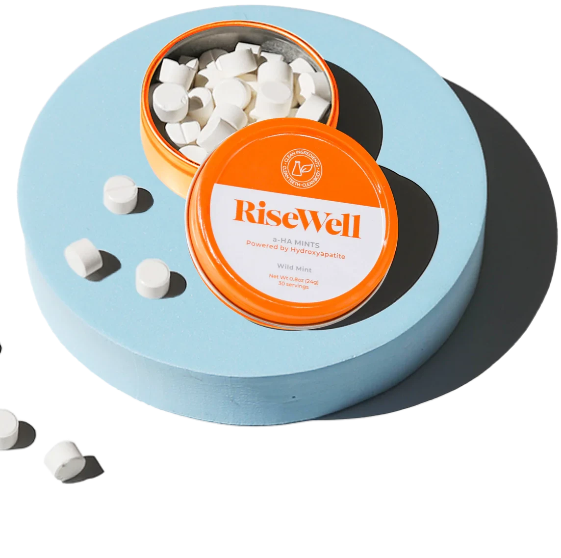 Container with orange lid featuring 'RiseWell' brand, filled with white mints on a white background.