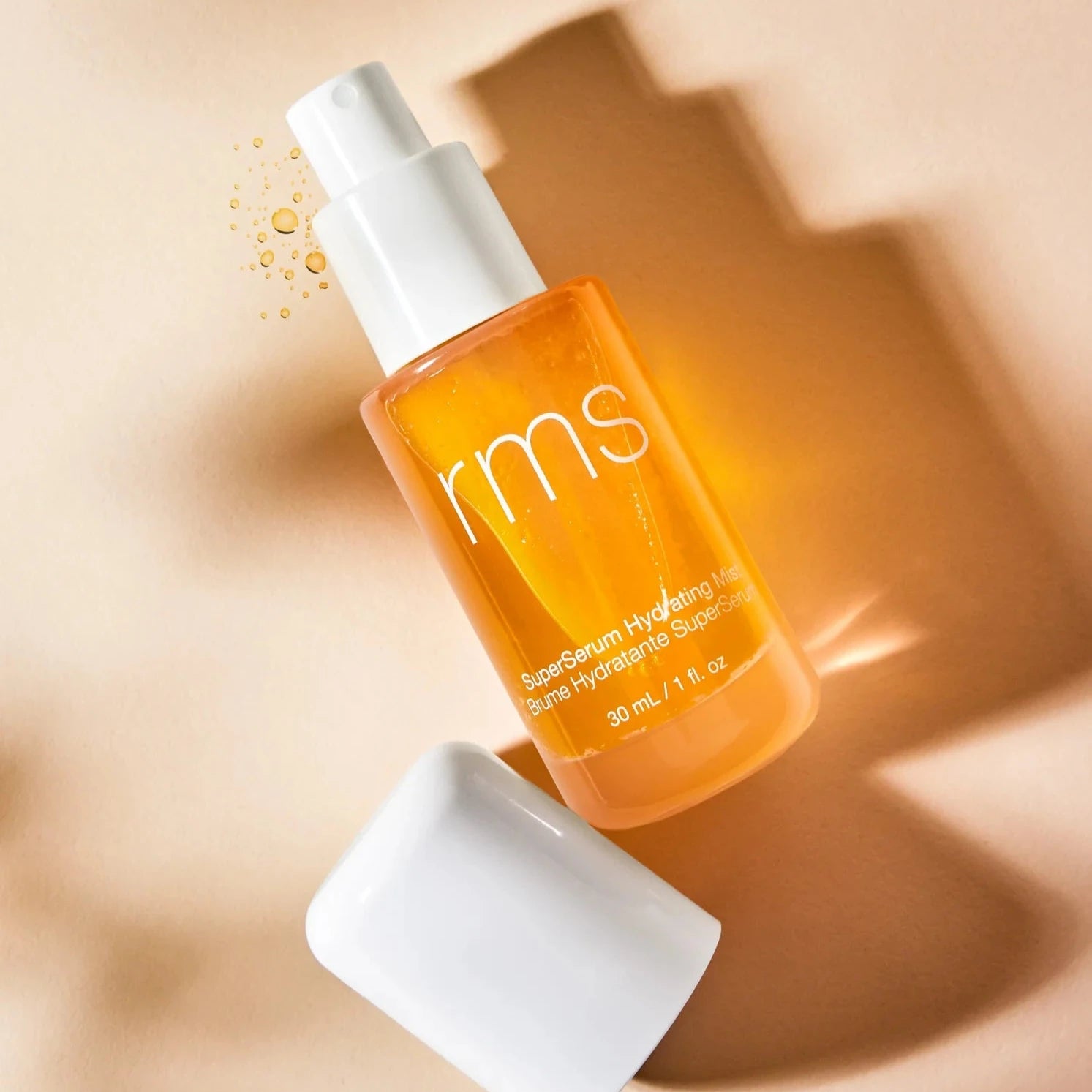 A bottle of RMS Beauty super serum hydrating mist, a clear bottle with a white top. Certified kind to biome, and replenishes and hydrates for 24 hours
