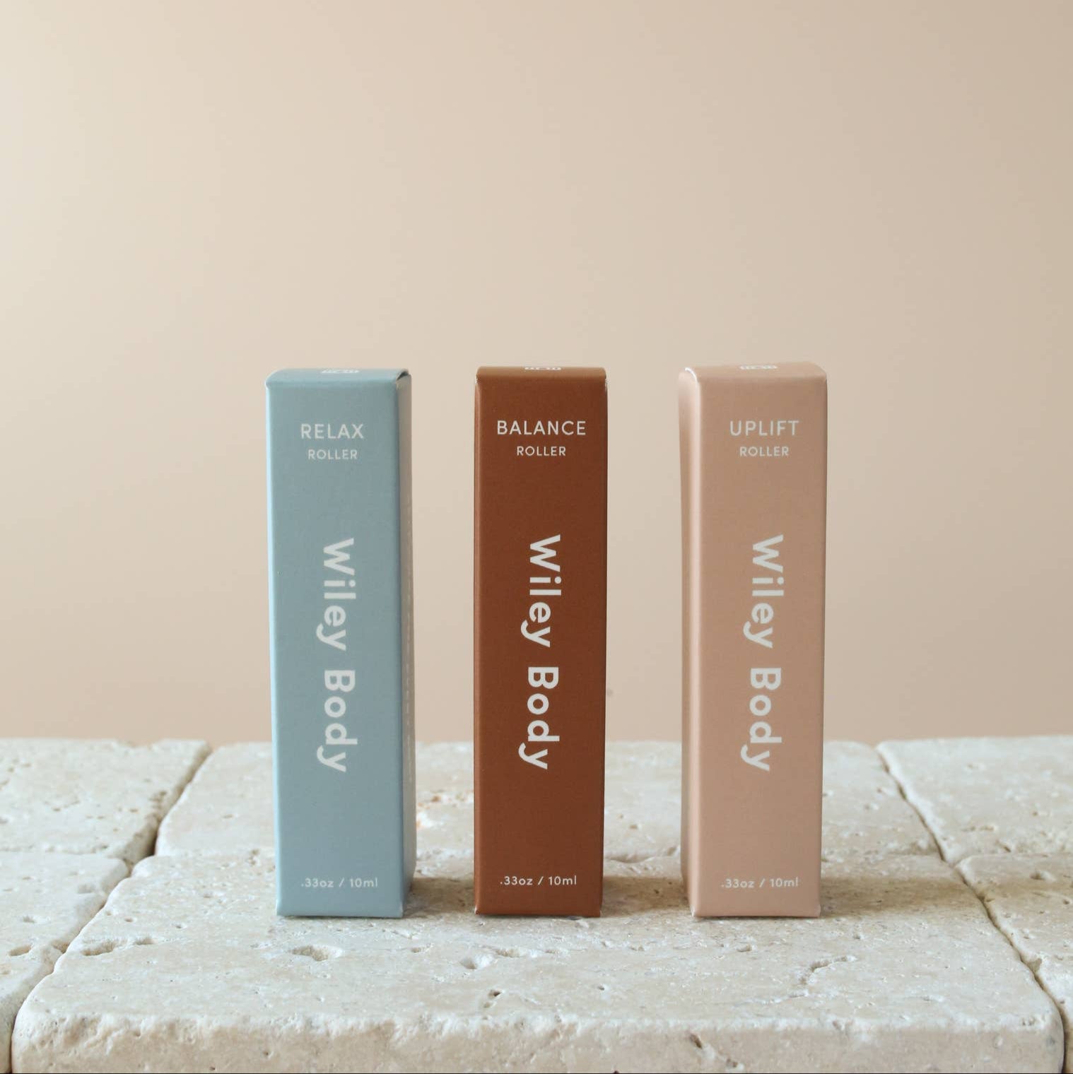 Three Wiley Body Rollers in a row in front of a beige background. 