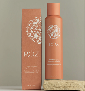 A bottle of ROZ Root Lift Spray next to an orange box. 
