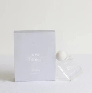 A bottle of Liis Rose Struck leaning against a light grey box