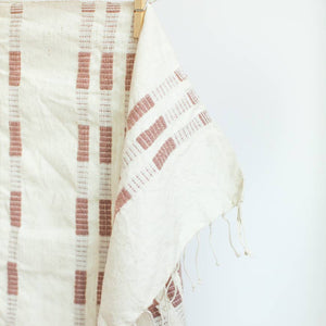 A rose and white tea towel with a clothespin.