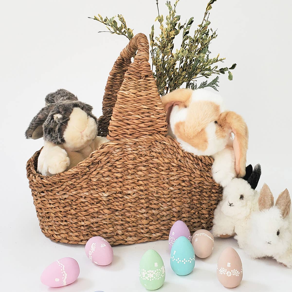 Savar Handwoven Picnic Basket with stuffed animal bunnies and some greenery. 