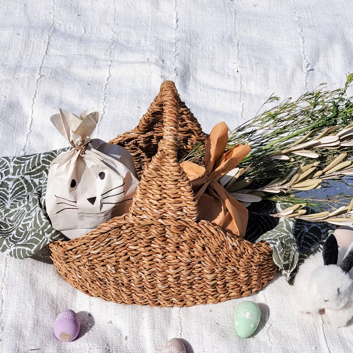 Savar Handwoven Picnic Basket with stuffed animal bunnies and some greenery. 