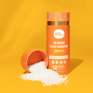 A bottle of Kind Laundry scent boosters on an orange background. 