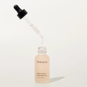 Skincare serum bottle with dropper labeled 'Rebrand' on a white background