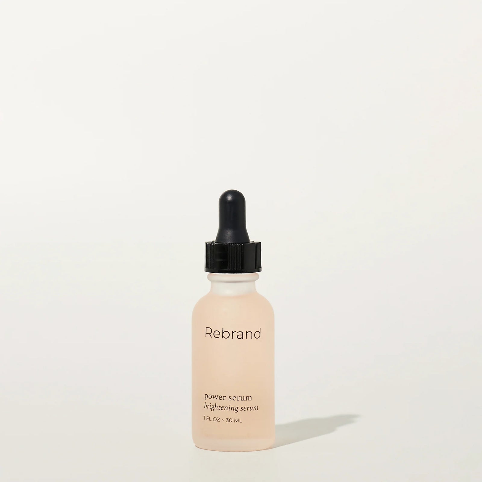 Skincare serum bottle with dropper labeled 'Rebrand' on a white background