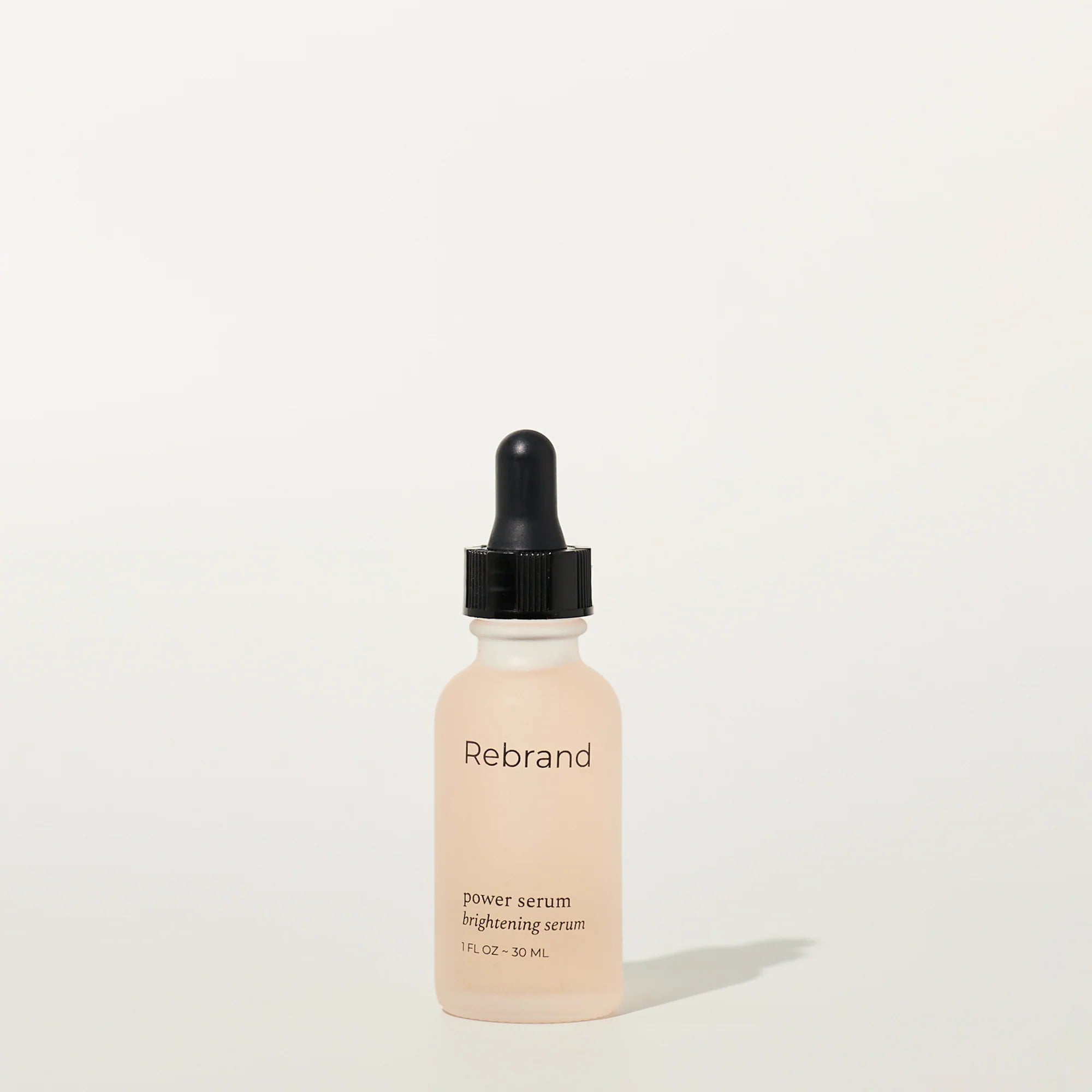 Skincare serum bottle with dropper labeled 'Rebrand' on a white background