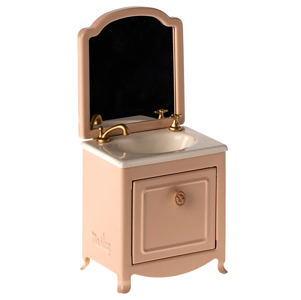 A small toy sink dresser in pink with a mirror and a closet, made of metal, designed for mouse playsets.