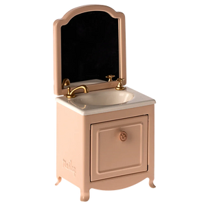 A small toy sink dresser in pink with a mirror and a closet, made of metal, designed for mouse playsets.