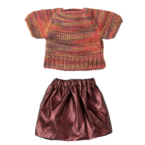 Knitted sweater and metallic skirt set on a white background