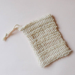 A fiber soap bag on a light pink surface. 