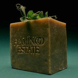 Block of green soap with 'Flamingo Estate' branding on a gradient background