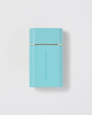 Turquoise rectangular product with gold accent on a light gray background