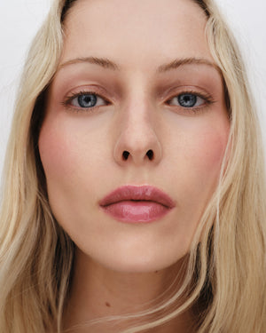 Close-up of a person with blonde hair and blue eyes on a white background