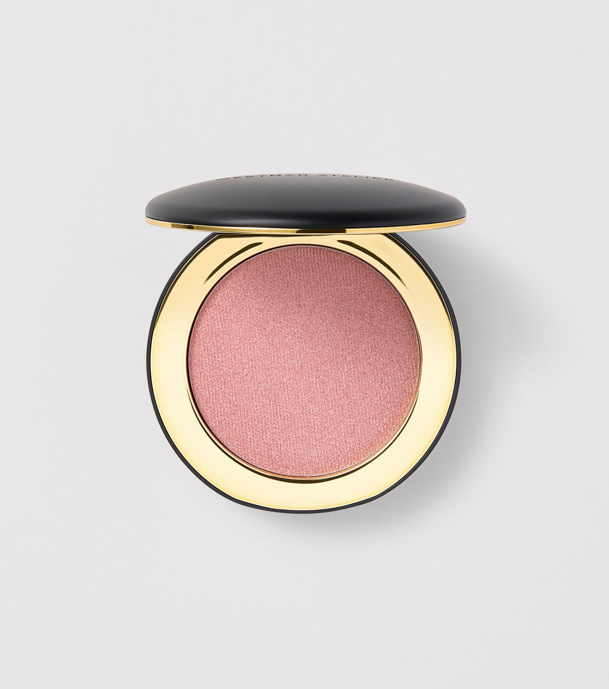 A compact pan of Westman Atelier tinted highlighter with a pinkish-shimmering shade.