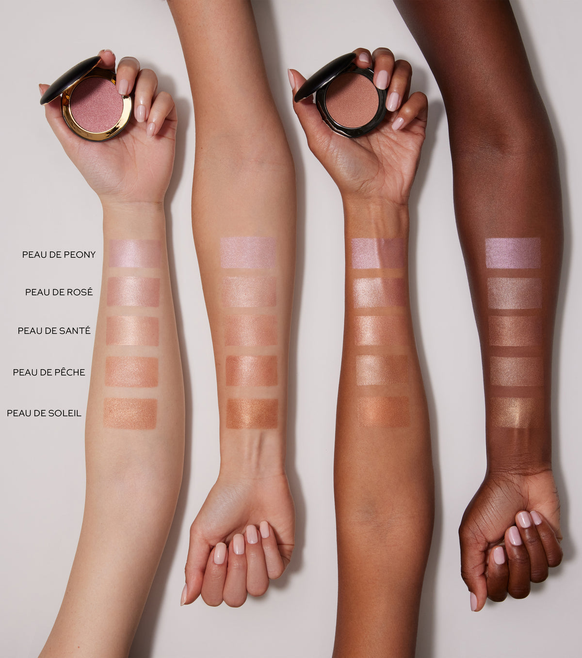 Three arms with makeup swatches on a neutral background