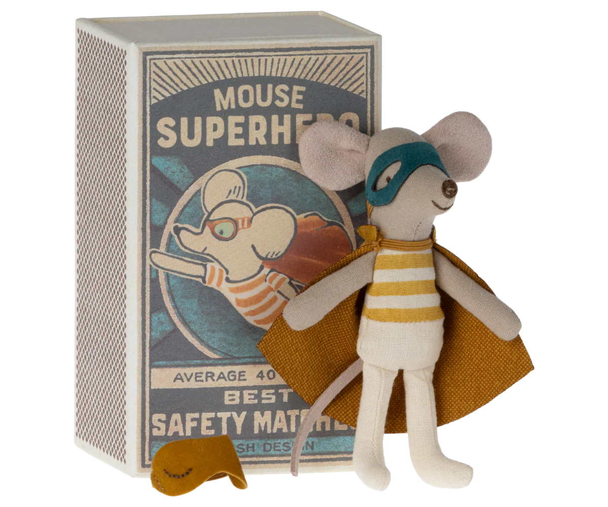 A toy mouse figurine dressed as a superhero, with a yellow and gray costume, inside a red and blue patterned matchbox. The matchbox lid has an illustration of the same mouse in action pose with text 'Mouse Superhero' and the text 'Average 40 Sticks Best Safety Matches Danish Design'.
