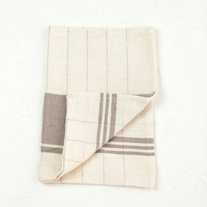 A brown and cream colored tea towel. 