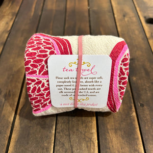 A red and beige tea towel pn a wood deck. 