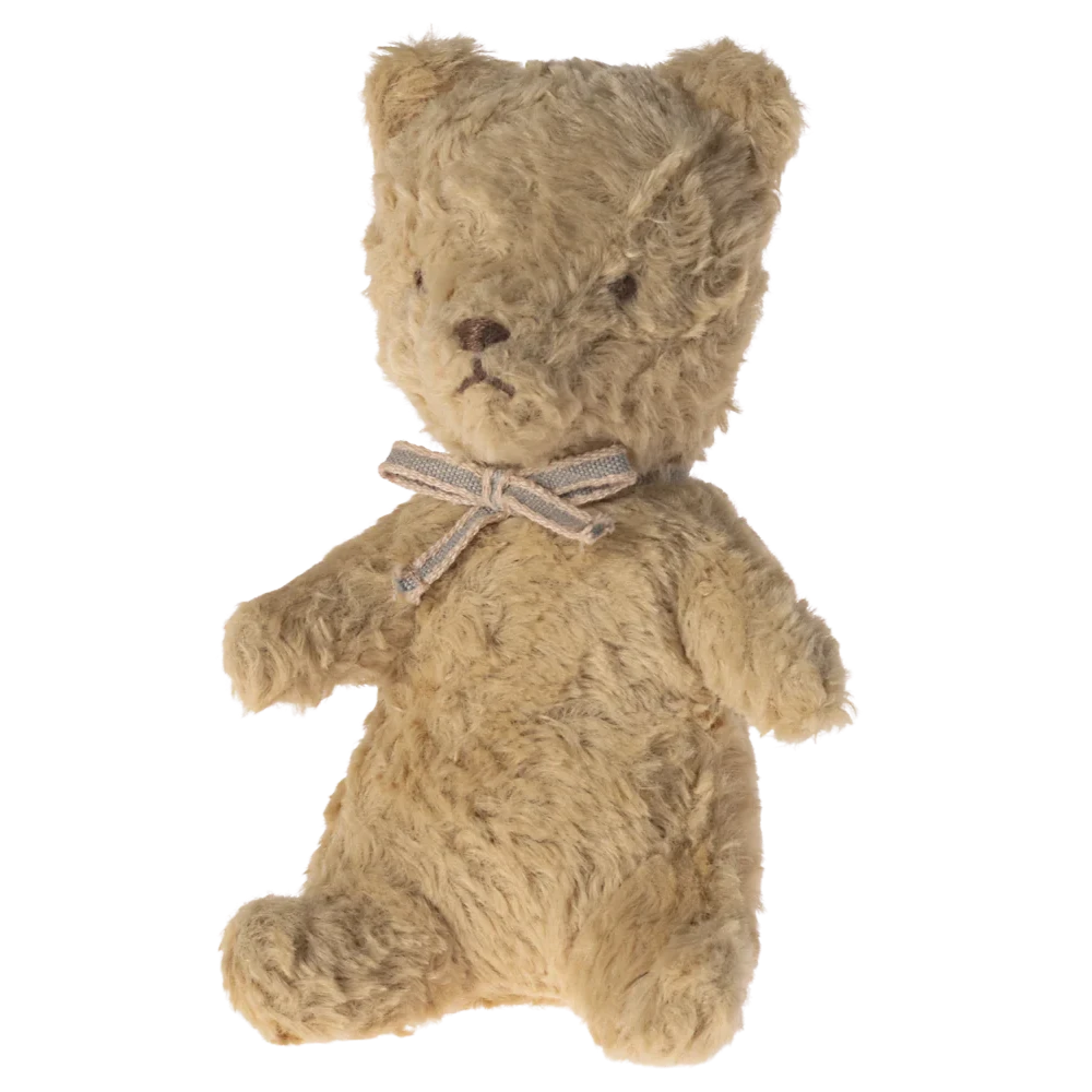 Brown teddy bear with a bow tie on a white background