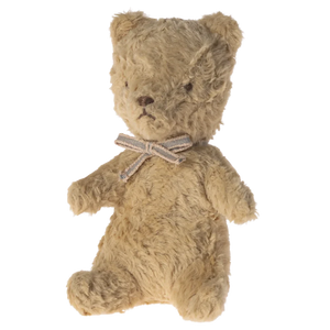 Brown teddy bear with a bow tie on a white background