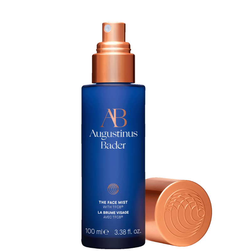 A bottle of Augustinus Bader The Face Mist, a blue bottle with a gold top