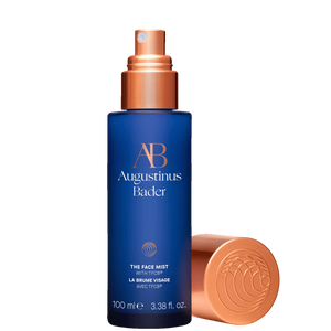 A bottle of Augustinus Bader The Face Mist, a blue bottle with a gold top