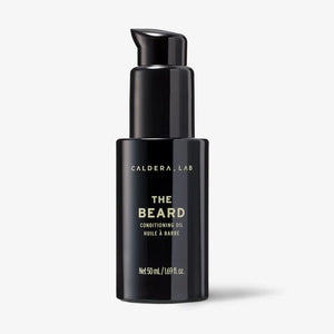 A black pump bottle labeled 'THE BEARD' by Caldera + Lab, which is a conditioning oil for beard and skin.