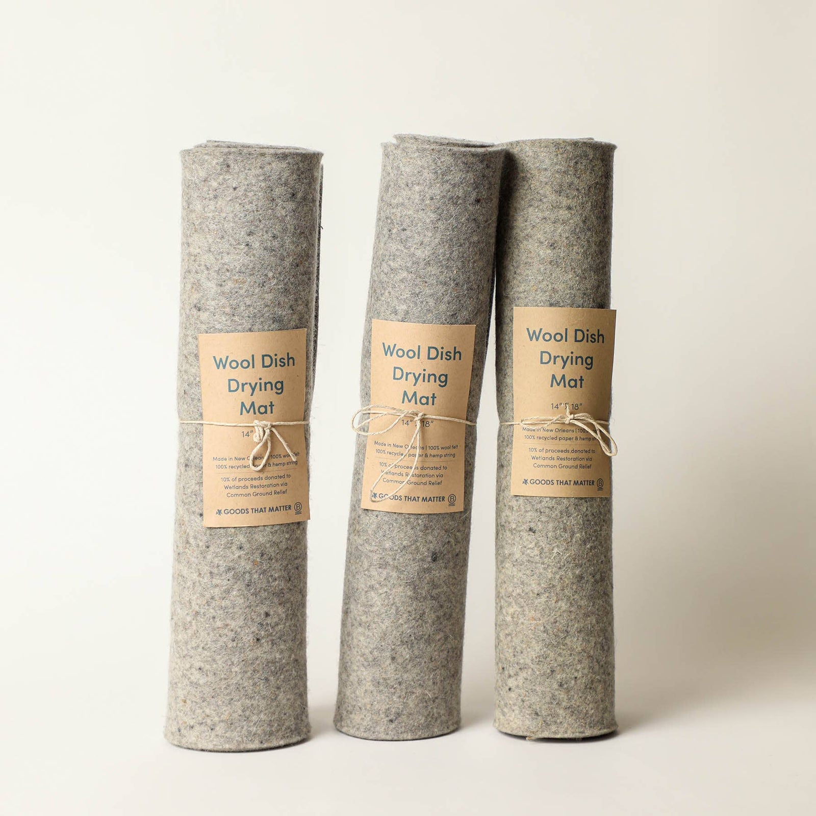 Three rolled-up dish drying mats with labels, set against a light background.