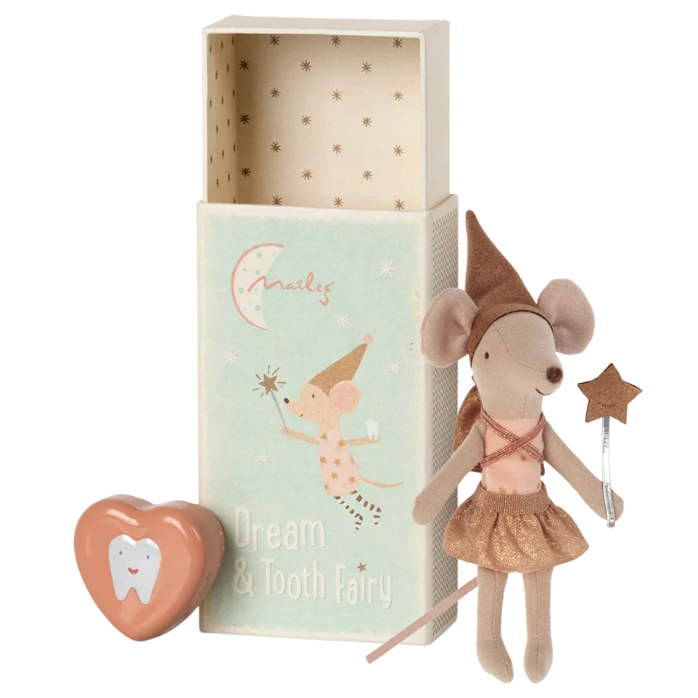A toy mouse dressed in a gold tutu with a shiny hat, standing next to an open matchbox with a 'Dream Big' message inside. A metal tooth box and a heart-shaped item are also visible.
