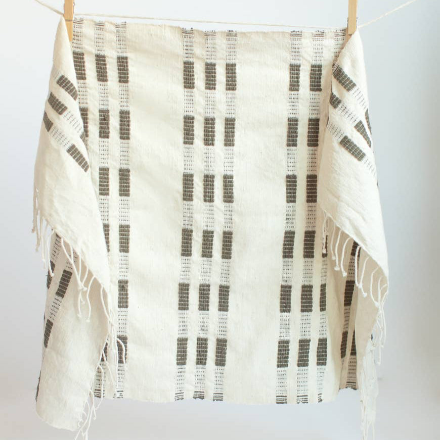 A green and white tea towel with a clothespin.