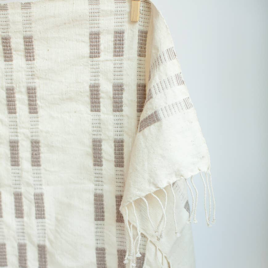 A brown and white tea towel with a clothespin.