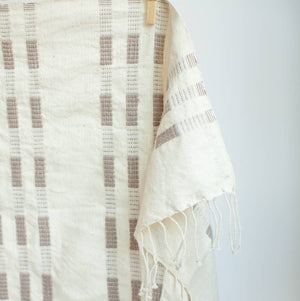 A brown and white tea towel with a clothespin.