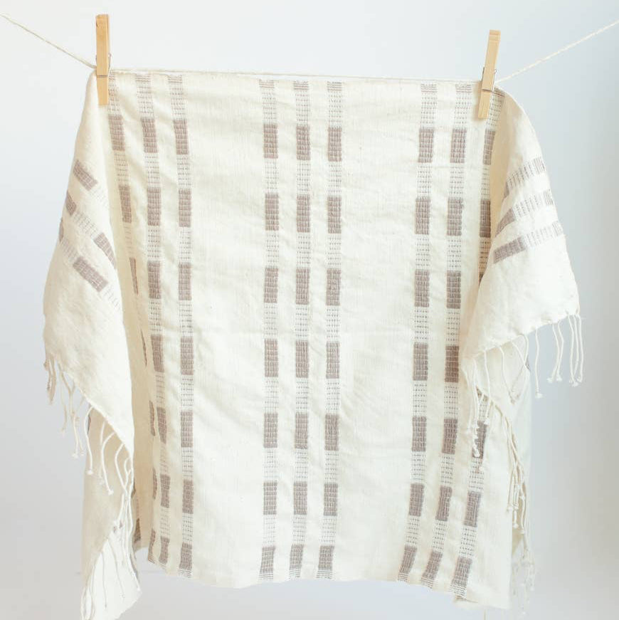 A brown and white tea towel with a clothespin.