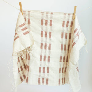 A brown and white tea towel with a clothespin.