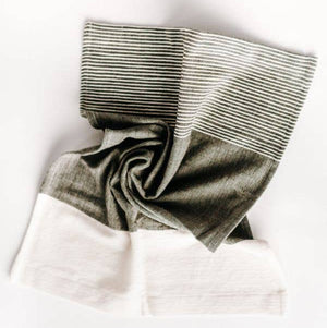 A folded Chesapeake tea towel featuring natural and accented colors with textured stripes, displayed on a white background.